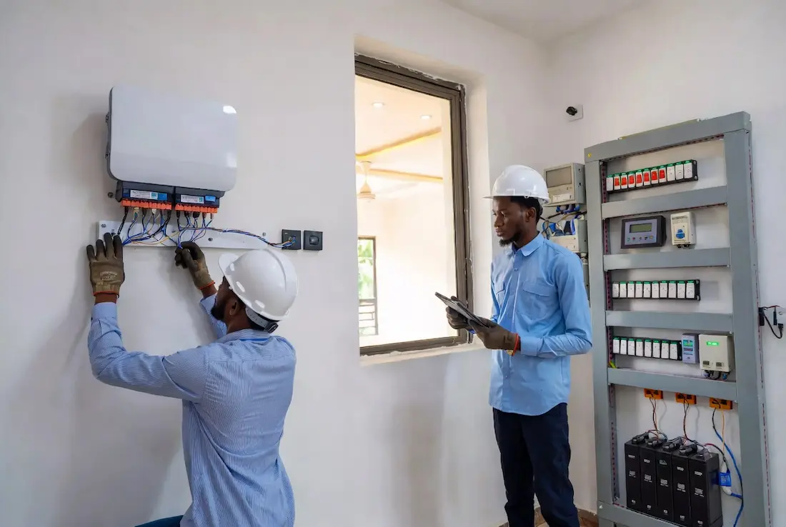 Cee Horizon technicians installing and inspecting a solar inverter and electrical system in a Nigerian home